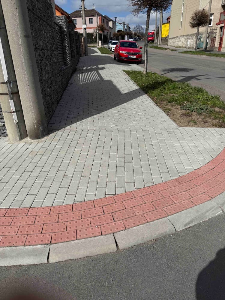 Pokládka chodníku ve Slaném s připraveným podložím a dlažbou